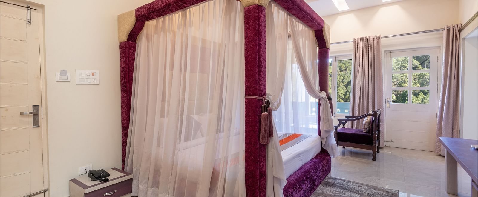 King size bed with a canopy in a beautifully decorated room at DLS Tehri Club Resort.
